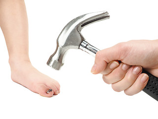 Image showing Someone holding a hammer over a child's foot with blue hallux na