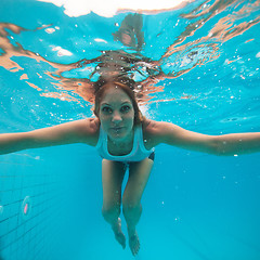 Image showing Female with eyes open underwater in swimming pool