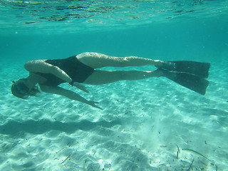 Image showing Female swimmer diving underwater in ocean