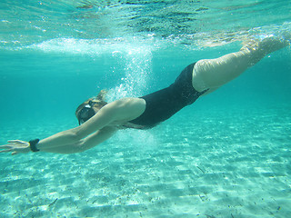 Image showing Female swimmer diving underwater in ocean