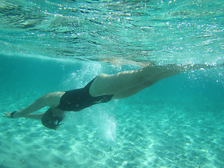 Image showing Female swimmer diving underwater in ocean