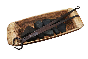 Image showing old wooden trough, stones and pliers on a white