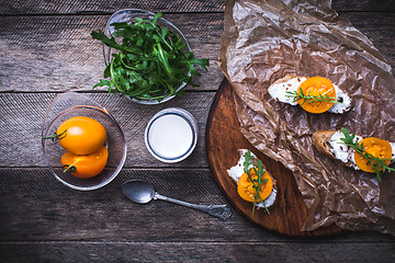 Image showing Bruschetta with tomatoes, joghurt and rucola on board 