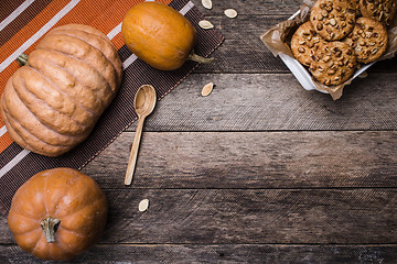 Image showing Pumpkins and tasty cookies with nuts on wooden table