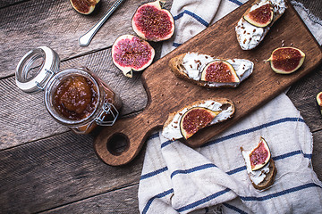 Image showing rustic style tasty Bruschetta with jam and figs on napkin