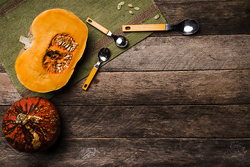 Image showing Pumpkins with spoons on green napkin and wood in Rustic style 