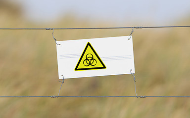 Image showing Border fence - Old plastic sign with a flag