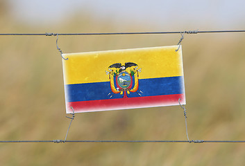 Image showing Border fence - Old plastic sign with a flag