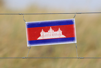 Image showing Border fence - Old plastic sign with a flag