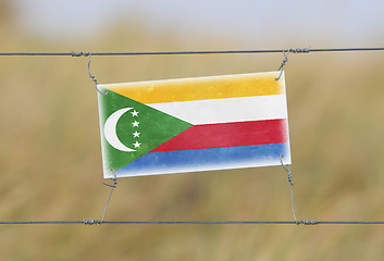 Image showing Border fence - Old plastic sign with a flag