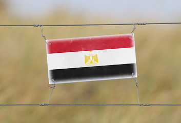 Image showing Border fence - Old plastic sign with a flag