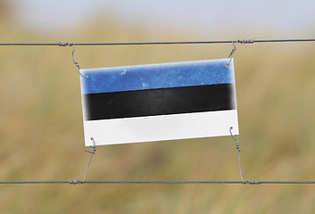 Image showing Border fence - Old plastic sign with a flag