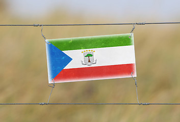 Image showing Border fence - Old plastic sign with a flag