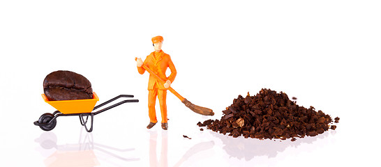 Image showing Miniature worker working on a coffee bean