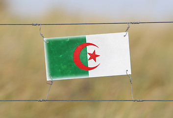 Image showing Border fence - Old plastic sign with a flag