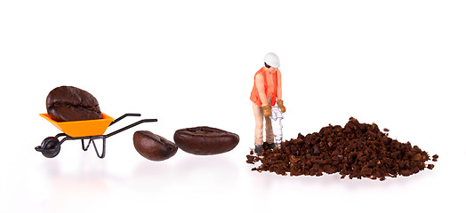 Image showing Miniature worker working on a coffee bean