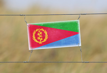 Image showing Border fence - Old plastic sign with a flag