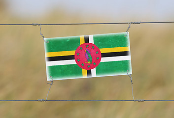 Image showing Border fence - Old plastic sign with a flag