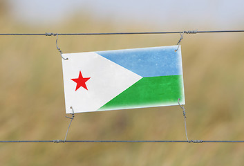 Image showing Border fence - Old plastic sign with a flag