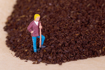 Image showing Miniature worker working on grinded coffee