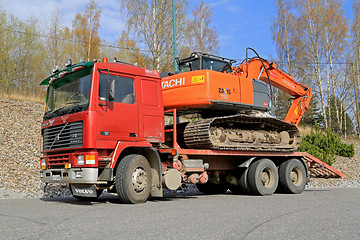 Image showing Red Volvo F12 Intercooler Hauls a Hitachi Zaxis Excavator