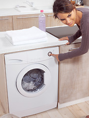 Image showing female pressing button on washing machine