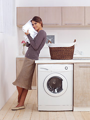 Image showing smiling woman in the laundry room 