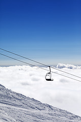 Image showing Ski slope, chair-lift and mountains under clouds