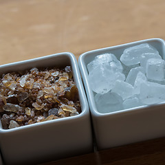 Image showing white and brown sugar on wooden table.