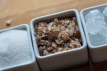 Image showing white and brown sugar on wooden table.