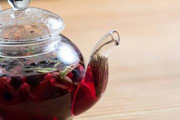 Image showing Hot tea with berries on wooden table