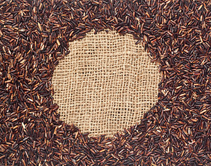 Image showing Red rice on burlap fabric