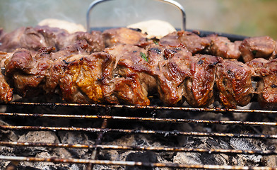 Image showing Closeup of beef meat on skewers over hot charcoal barbecue