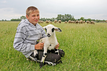 Image showing Close up of boy holding goatling