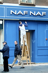 Image showing Worker wall painting on NAF NAF store