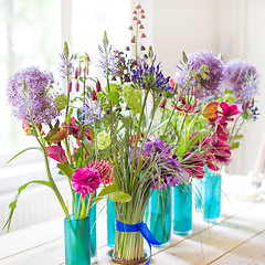 Image showing Beautiful spring flowers on wooden table.