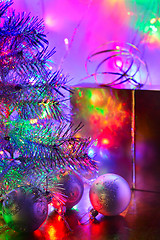 Image showing Christmas tree, balls, box, lit by fairy lights