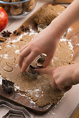 Image showing Close up little hands making the gingerbread cookies