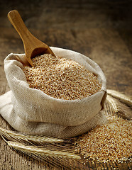 Image showing wheat grits sack on old wooden table