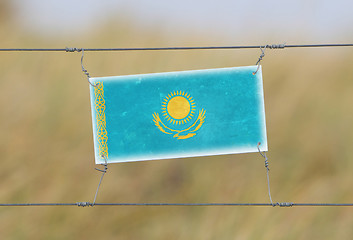 Image showing Border fence - Old plastic sign with a flag