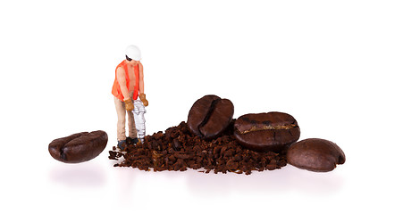 Image showing Miniature worker working on a coffee bean