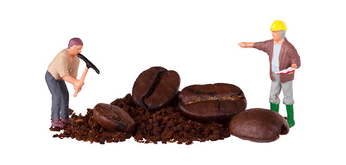 Image showing Miniature worker working on a coffee bean