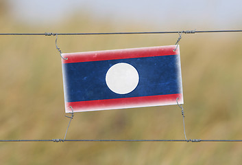 Image showing Border fence - Old plastic sign with a flag