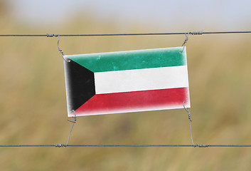 Image showing Border fence - Old plastic sign with a flag