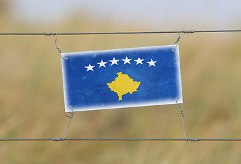 Image showing Border fence - Old plastic sign with a flag