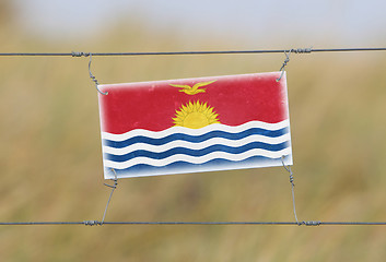 Image showing Border fence - Old plastic sign with a flag