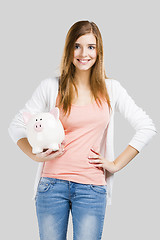 Image showing Blonde woman with a piggy bank