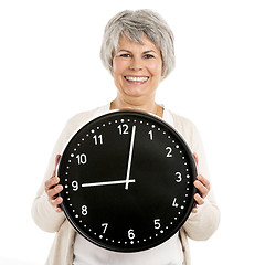 Image showing Elderly woman holding a clock