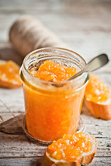 Image showing orange jam in a glass jar and bread