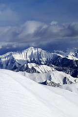 Image showing Off-piste snowy slope and cloudy mountains